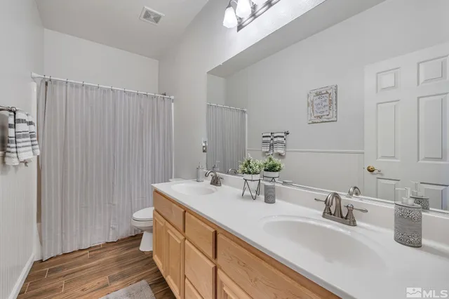 a bedroom with a bed and a potted plant on the dresser