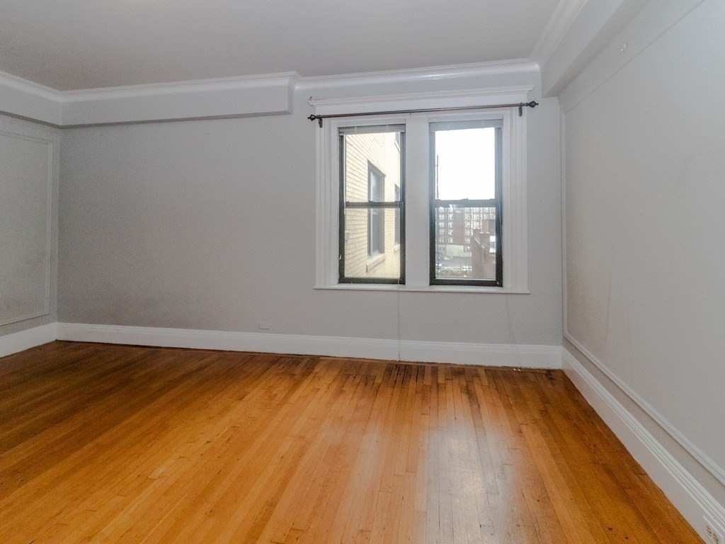 466 Commonwealth Avenue, Unit 503 Boston, MA 02215 - Photo 12 of 17 a view of an empty room with wooden floor and a window