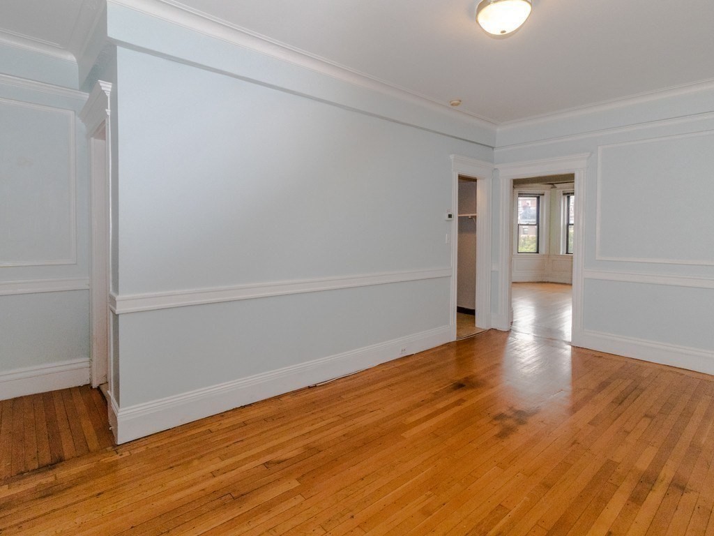 466 Commonwealth Avenue, Unit 503 Boston, MA 02215 - Photo 5 of 17 wooden floor in an empty room with a window
