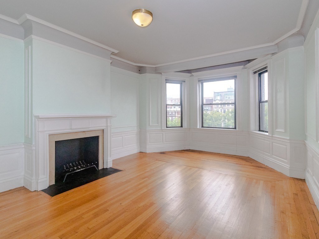 466 Commonwealth Avenue, Unit 503 Boston, MA 02215 - Photo 8 of 17 an empty room with windows and fireplace