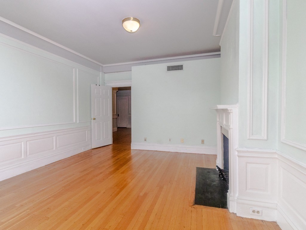 466 Commonwealth Avenue, Unit 503 Boston, MA 02215 - Photo 9 of 17 a view of an empty room with wooden floor and a window