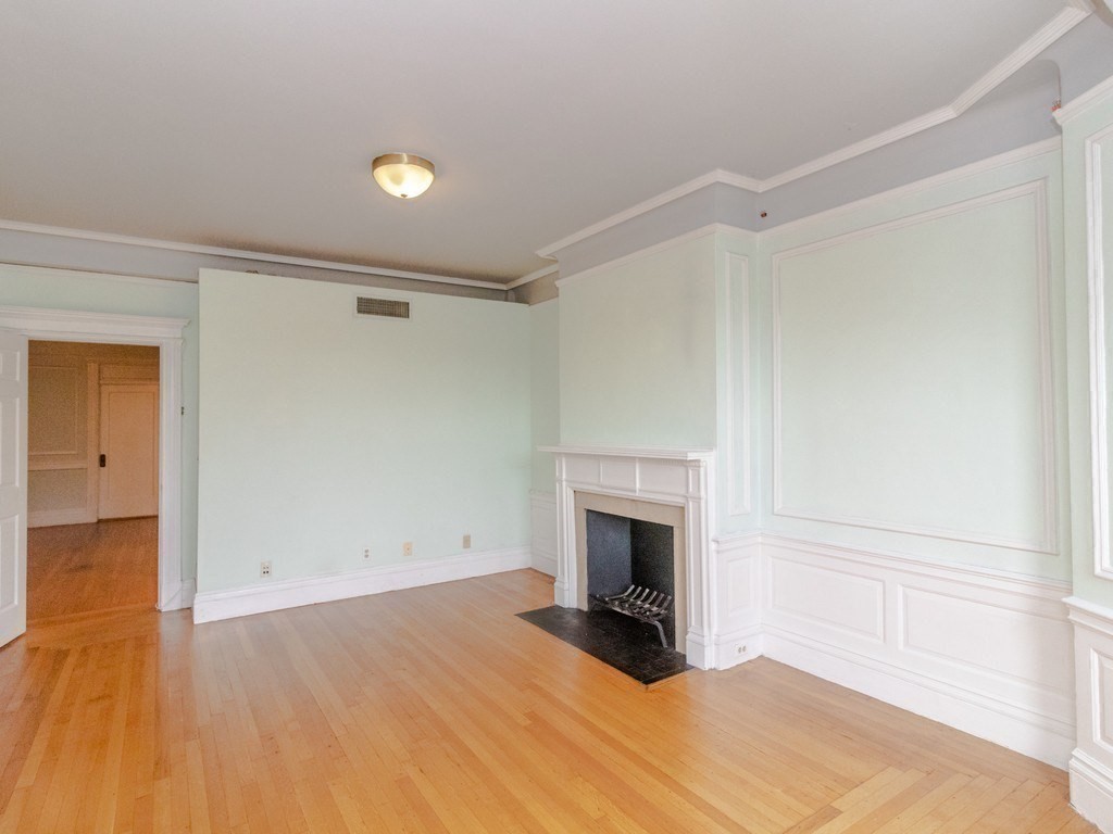 466 Commonwealth Avenue, Unit 503 Boston, MA 02215 - Photo 10 of 17 a view of empty room with wooden floor and fireplace