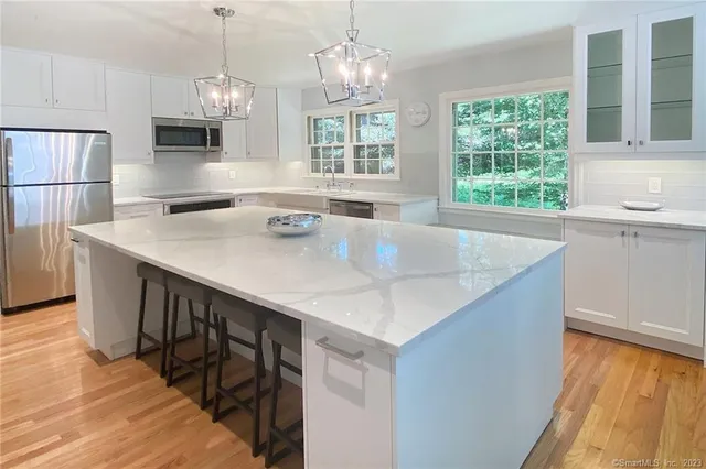 a kitchen with stainless steel appliances granite countertop a sink a stove and a refrigerator