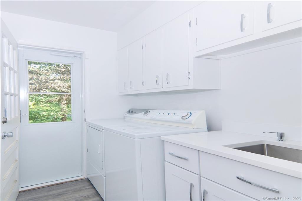 177 Brett Road Fairfield, CT 06824 - Photo 11 of 26 a utility room with cabinets washer and dryer