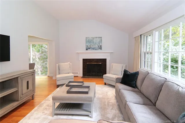 a living room with furniture a fireplace and a flat screen tv