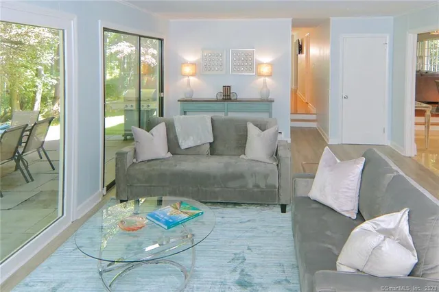 a living room with furniture and a floor to ceiling window