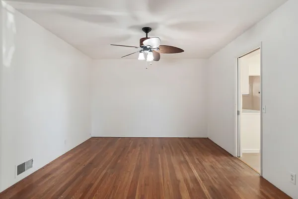 a view of empty room with wooden floor