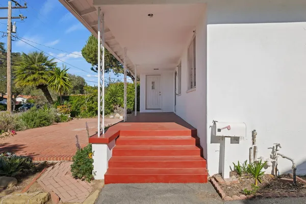 a view of a backyard with plants and outdoor seating