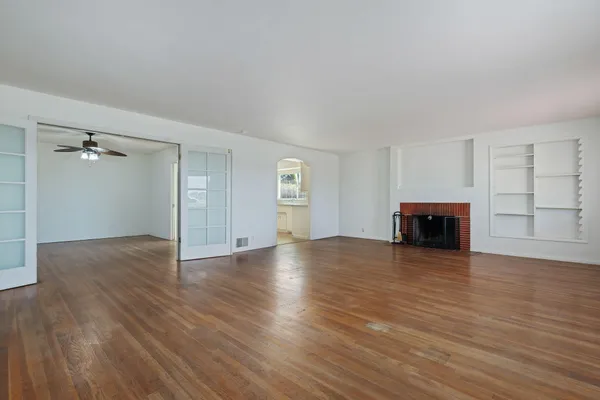 an empty room with wooden floor and cabinet
