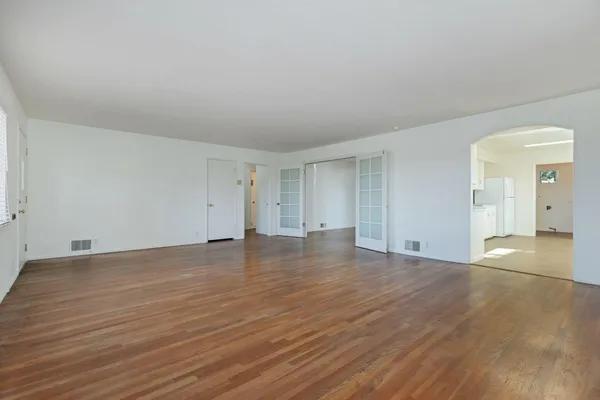 a view of empty room with wooden floor