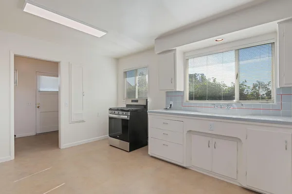 a room with white cabinets and a window