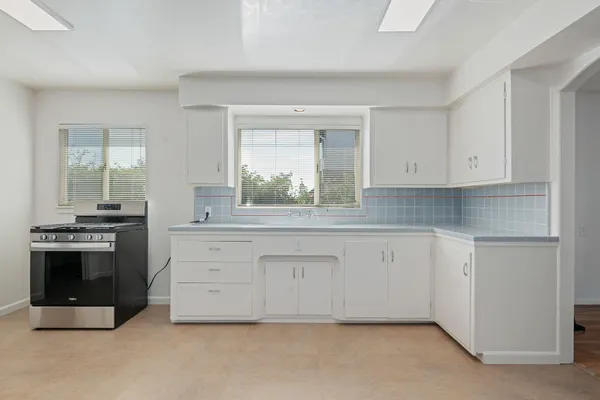 a kitchen with granite countertop white cabinets and stainless steel appliances