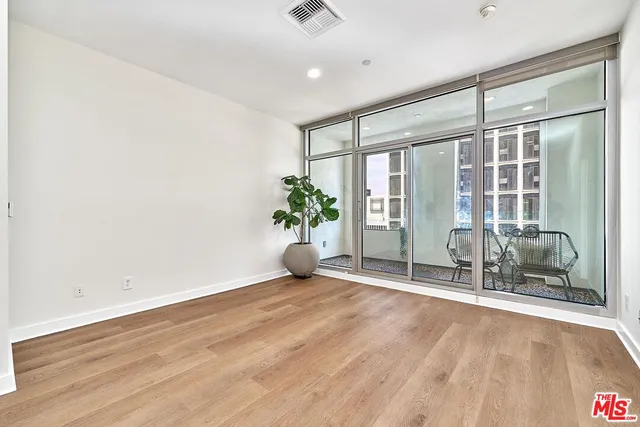 an empty room with wooden floor and mirror