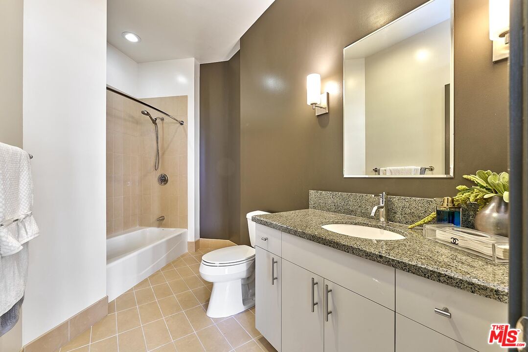 3810 Wilshire Boulevard, Unit 404 Los Angeles, CA 90010 - Photo 16 of 43 a bathroom with a granite countertop sink toilet and shower