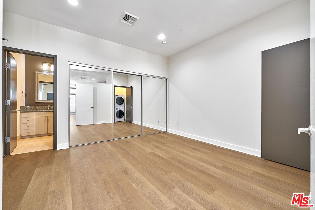 3810 Wilshire Boulevard, Unit 404 Los Angeles, CA 90010 - Photo 21 of 43 a view of an empty room with wooden floor and kitchen view