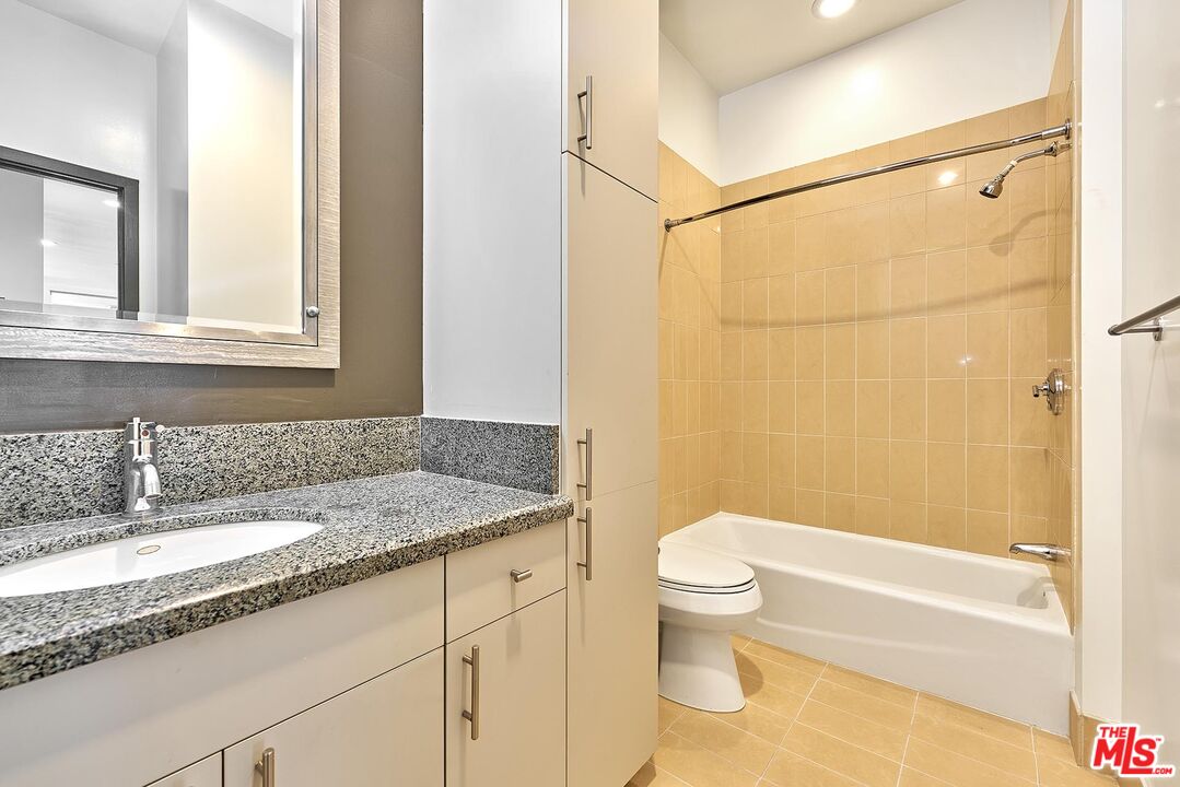 3810 Wilshire Boulevard, Unit 404 Los Angeles, CA 90010 - Photo 25 of 43 a bathroom with a granite countertop sink a toilet and shower