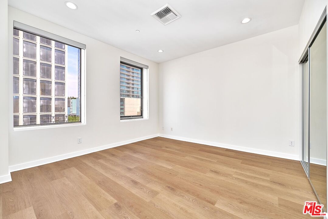 3810 Wilshire Boulevard, Unit 404 Los Angeles, CA 90010 - Photo 26 of 43 a view of an empty room with a window and wooden floor