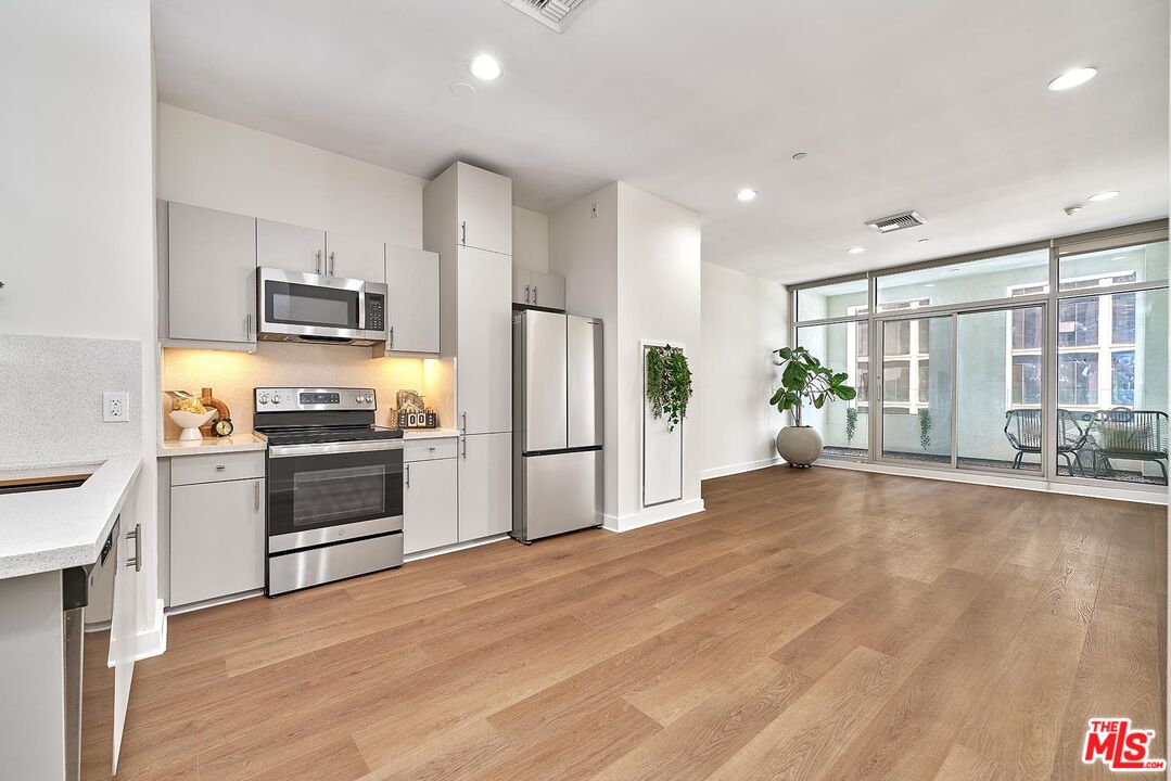 3810 Wilshire Boulevard, Unit 404 Los Angeles, CA 90010 - Photo 4 of 43 a kitchen with stainless steel appliances a refrigerator and a stove top oven