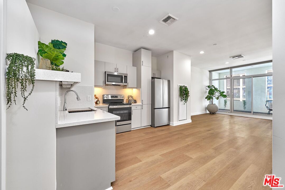 3810 Wilshire Boulevard, Unit 404 Los Angeles, CA 90010 - Photo 5 of 43 a kitchen with stainless steel appliances a refrigerator sink and stove