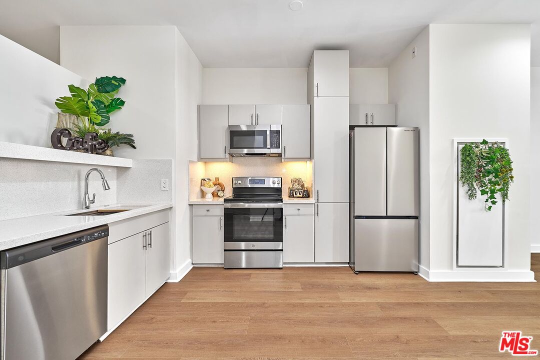 3810 Wilshire Boulevard, Unit 404 Los Angeles, CA 90010 - Photo 6 of 43 a kitchen with a refrigerator and a sink