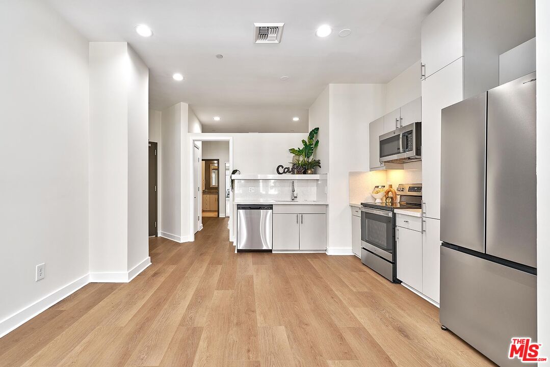 3810 Wilshire Boulevard, Unit 404 Los Angeles, CA 90010 - Photo 7 of 43 a kitchen with stainless steel appliances a refrigerator sink and cabinets