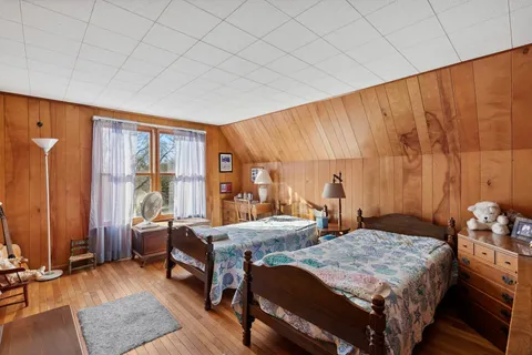 a bedroom with two beds and large windows