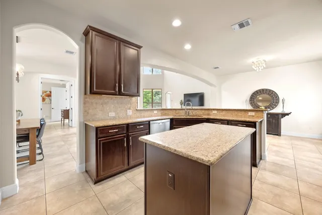 a kitchen with a stove sink and cabinets
