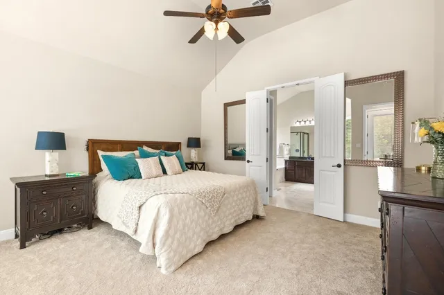 a spacious bedroom with a bed and ceiling fan