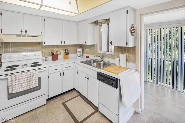 a kitchen with granite countertop a sink a stove and cabinets