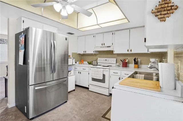 a kitchen with cabinets stainless steel appliances and a window