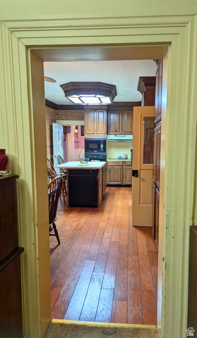 190 North 200 E Street Beaver, UT 84713 - Photo 12 of 40 Kitchen featuring wood-finish flooring, dark wood cabinetry, a central island with integrated dishwasher, and a built-in microwave