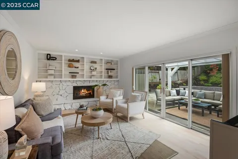 a living room with furniture large window and a fireplace