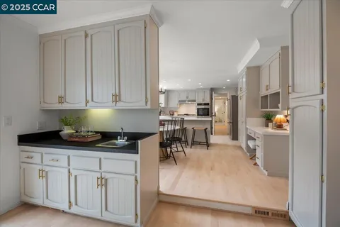 a kitchen with stainless steel appliances granite countertop a stove a sink and white cabinets