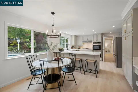 a dining room with furniture a chandelier and wooden floor