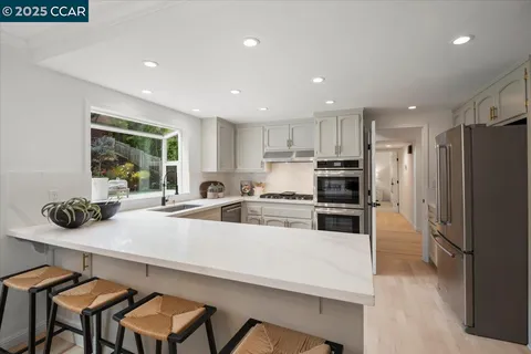 a kitchen with refrigerator and chairs