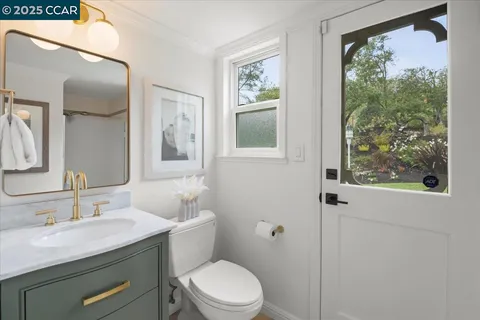 a bathroom with a granite countertop sink toilet and a mirror