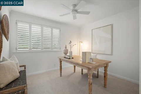 a view of a workspace with furniture and a window