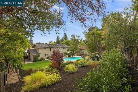 a view of a house with a big yard and large trees