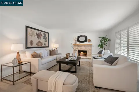 a living room with furniture a fireplace and a large window