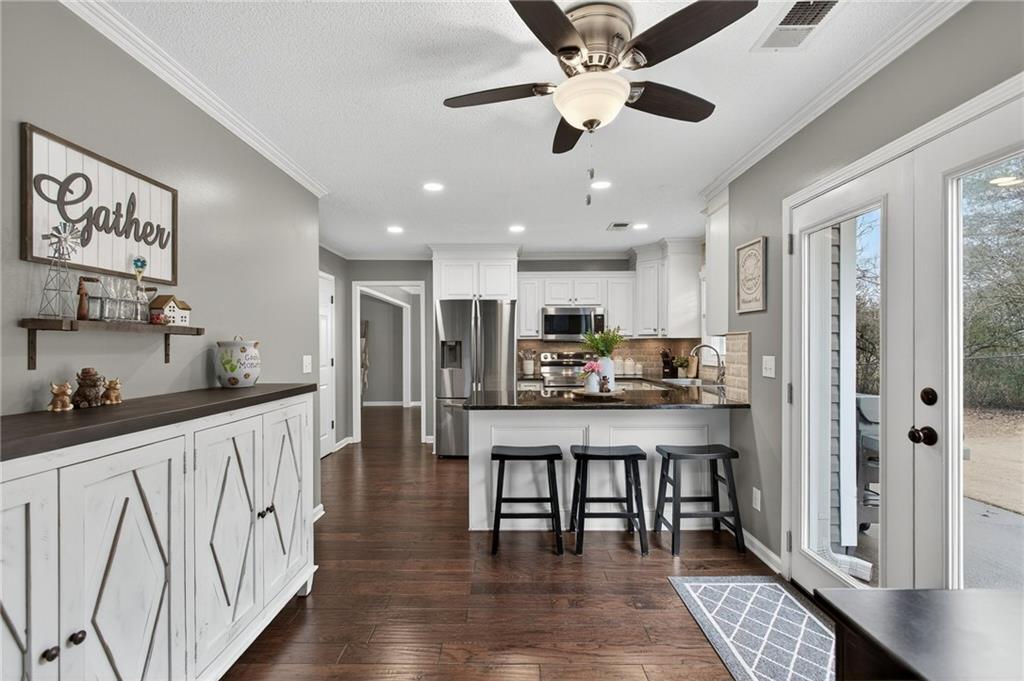 15 Bluegrass Cove Northeast Cartersville, GA 30121 - Photo 25 of 51 a kitchen with stainless steel appliances kitchen island granite countertop a refrigerator a sink a stove and white cabinets with wooden floor