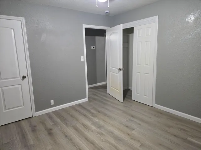 an empty room with wooden floor and closet