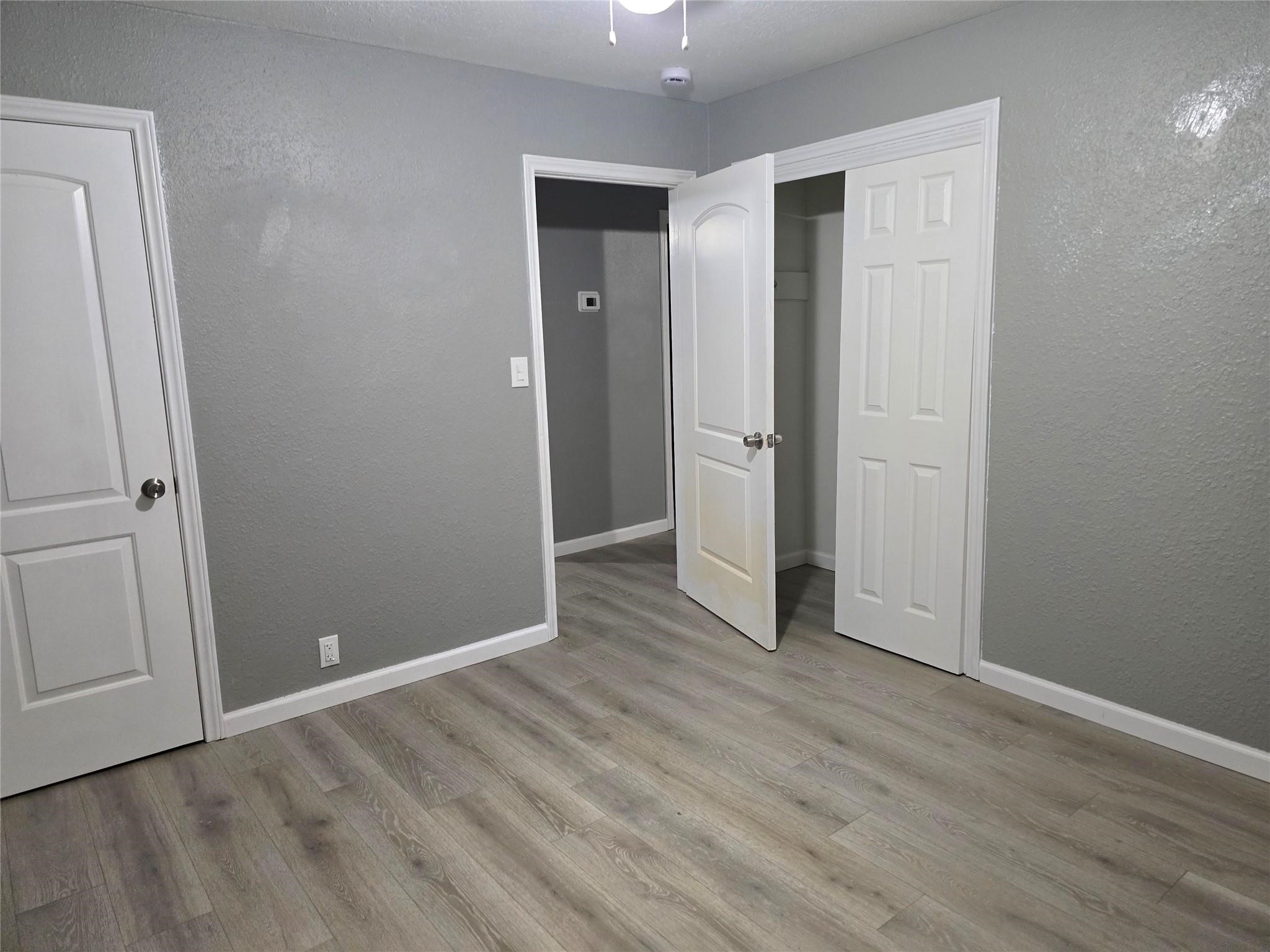 9938 Kittrell Street Houston, TX 77034 - Photo 9 of 12 an empty room with wooden floor and closet