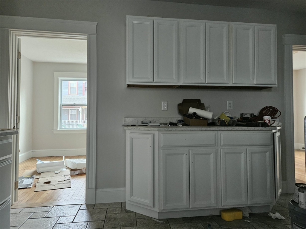 9 Victoria Street, Unit 1 Lowell, MA 01851 - Photo 3 of 8 a kitchen with a sink and cabinets