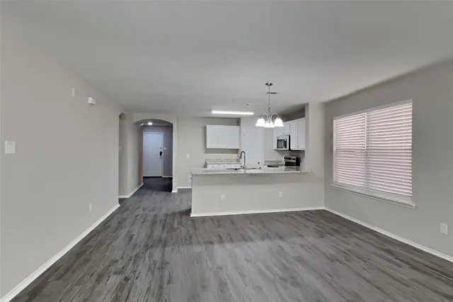 a large kitchen with cabinets wooden floor and stainless steel appliances