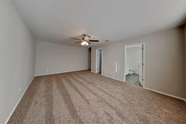 a room with stainless steel appliances kitchen island wooden floors and white walls