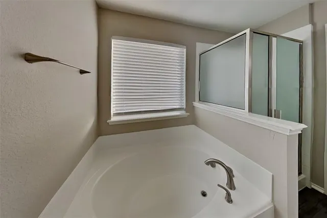 a bathroom with a granite countertop double vanity sink a mirror and a shower