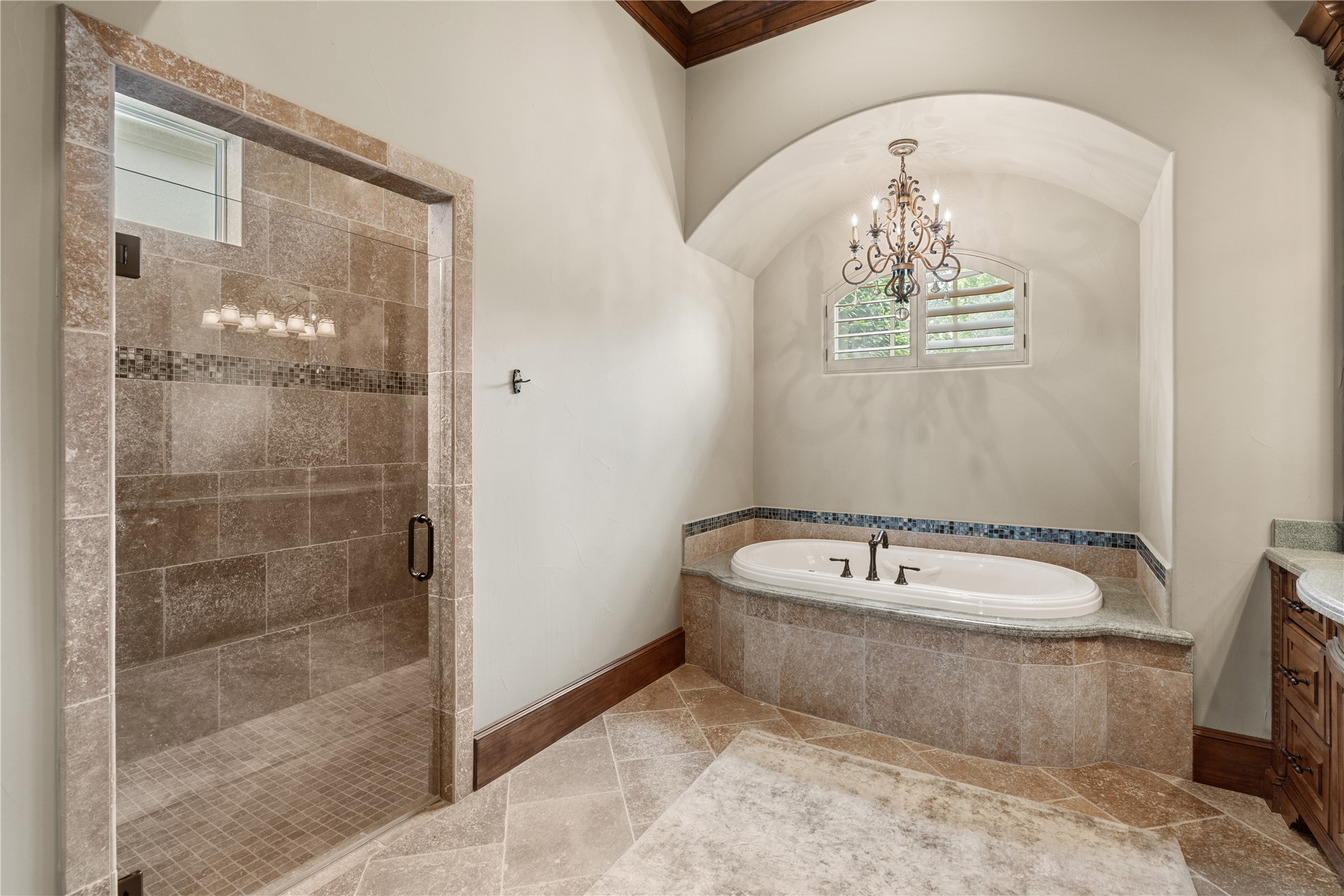 12349 Longmire Trace Conroe, TX 77304 - Photo 15 of 48 Spa-inspired bath with arched ceiling, chandelier, soaking tub, and oversized tiled walk-in shower.