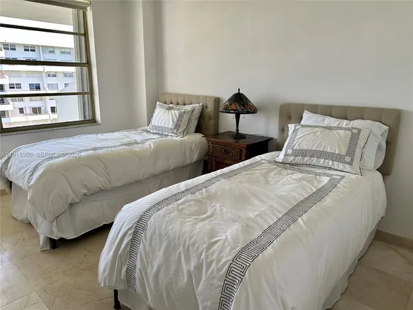 a bedroom with two beds and a window