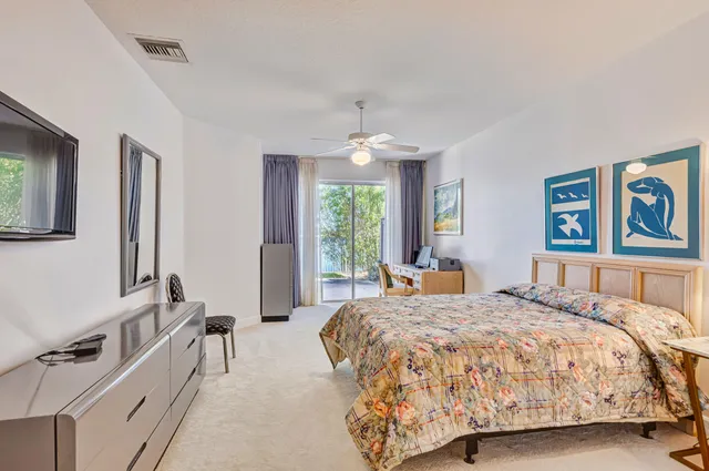 a bed sitting in a spacious bedroom next to a window