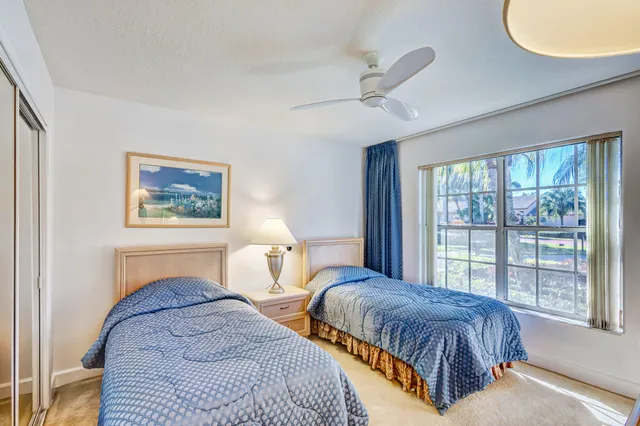 a bedroom with two beds and a large window